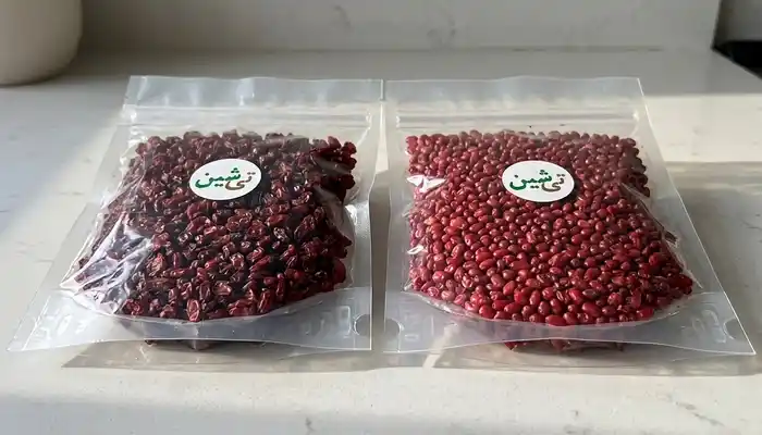 دو بسته شفاف حاوی زرشک روی سطح آشپزخانه با نشان تی شین